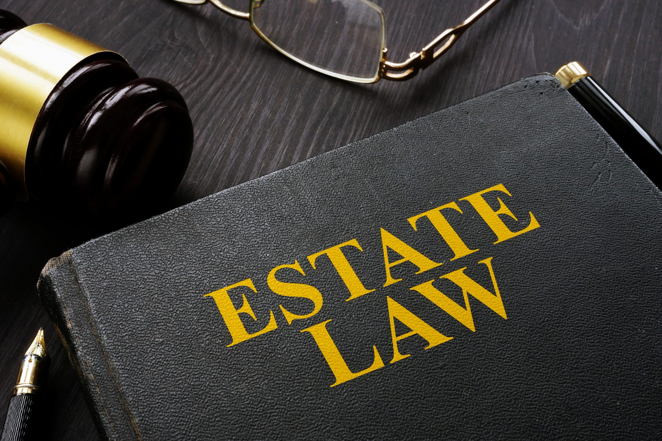 Estate law book with gavel and glasses.