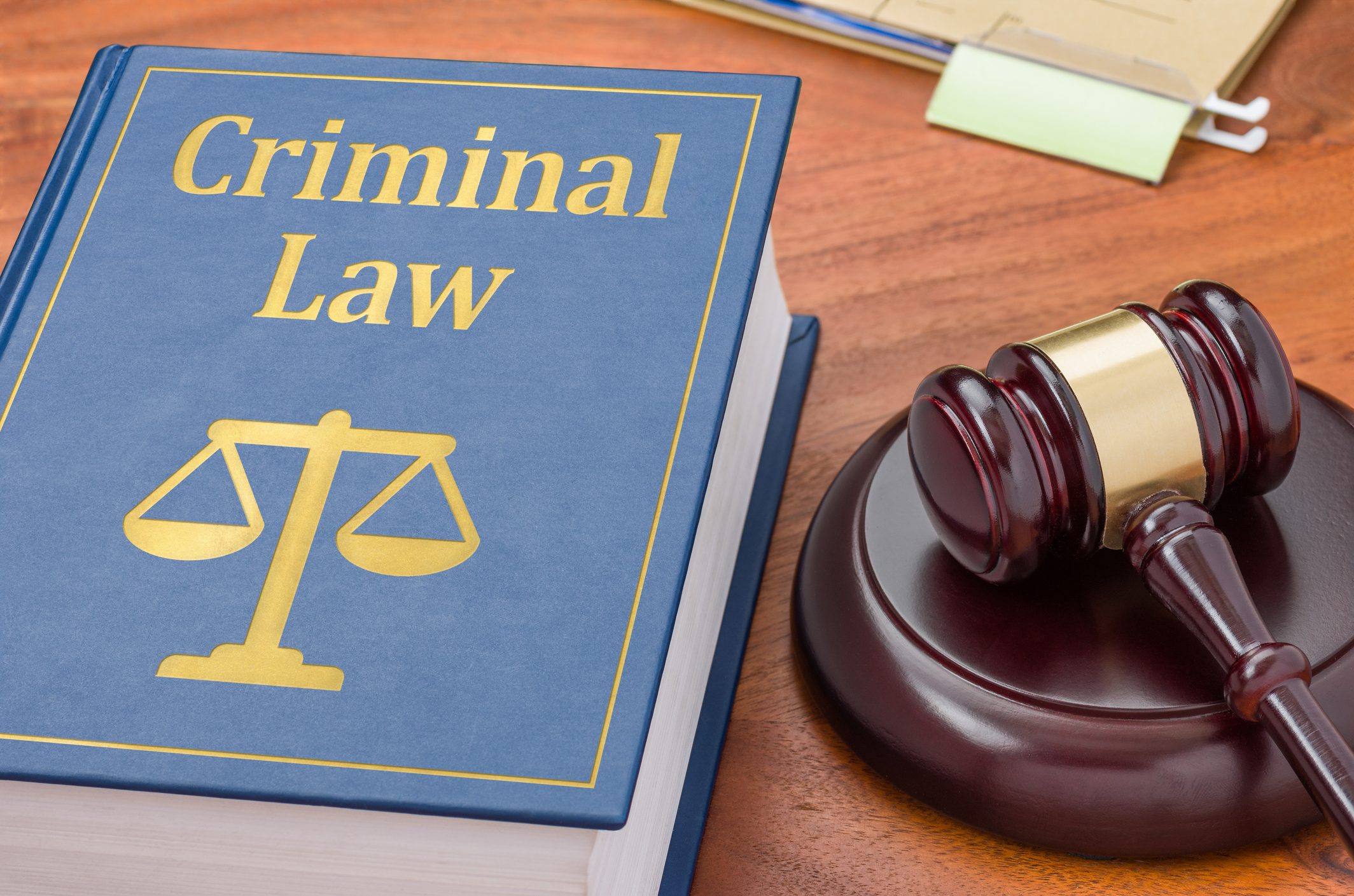 Criminal law book and gavel on table.